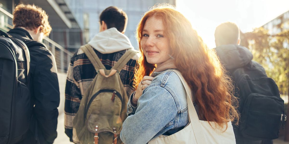 Girl looks over shoulder with red hair