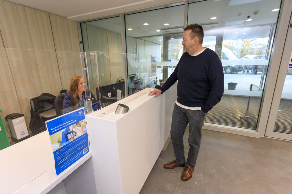 Patient talking to reception staff