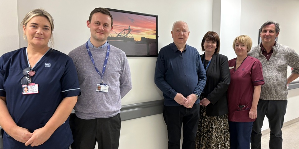 Image of people standing by a donated picture frame  