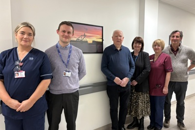 Image of people standing by a donated picture frame  